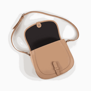 tan leather postbag with adjustable shoulder strap and flap closure, open showing interior compartments