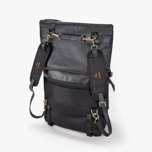 A black convertible eco-leather backpack purse with gold hardware and adjustable straps, photographed on a white background.