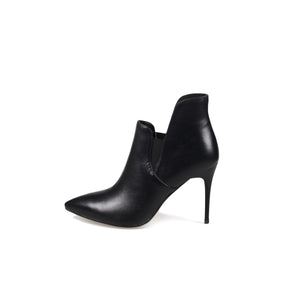 A black leather asymmetrical ankle boot with a pointed toe and stiletto heel, photographed on a white background.