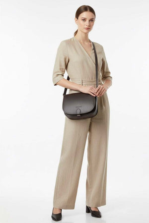 Woman wearing beige jumpsuit carrying black VOOC Vintage P27 Postbag leather shoulder bag