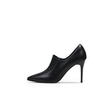 A black leather stiletto heel with a pointed toe and elastic upper detail, photographed on a white background.