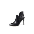 A black leather asymmetrical ankle boot with a pointed toe and stiletto heel, photographed on a white background.