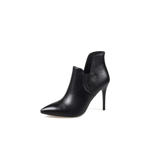 A black leather asymmetrical ankle boot with a pointed toe and stiletto heel, photographed on a white background.
