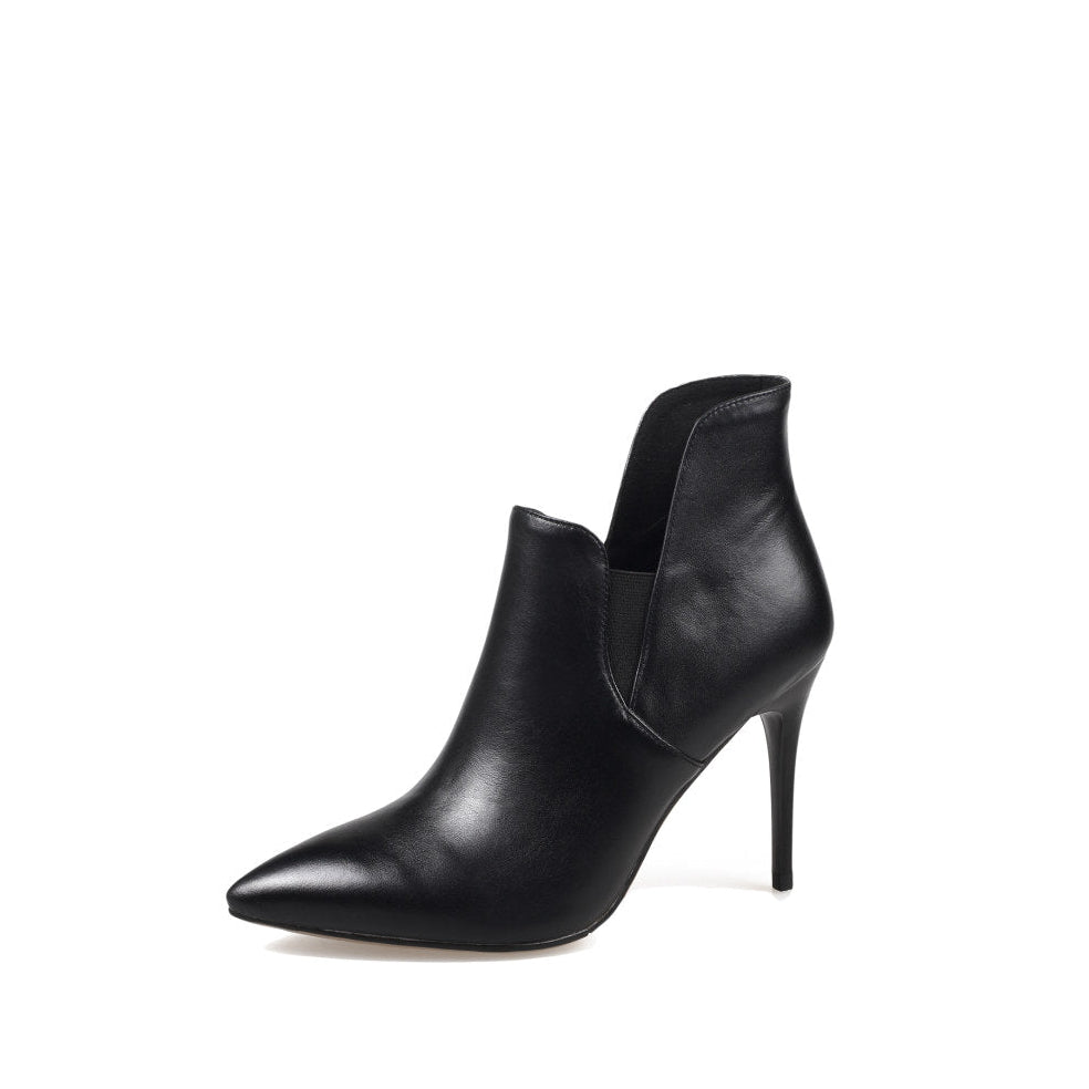A black leather asymmetrical ankle boot with a pointed toe and stiletto heel, photographed on a white background.