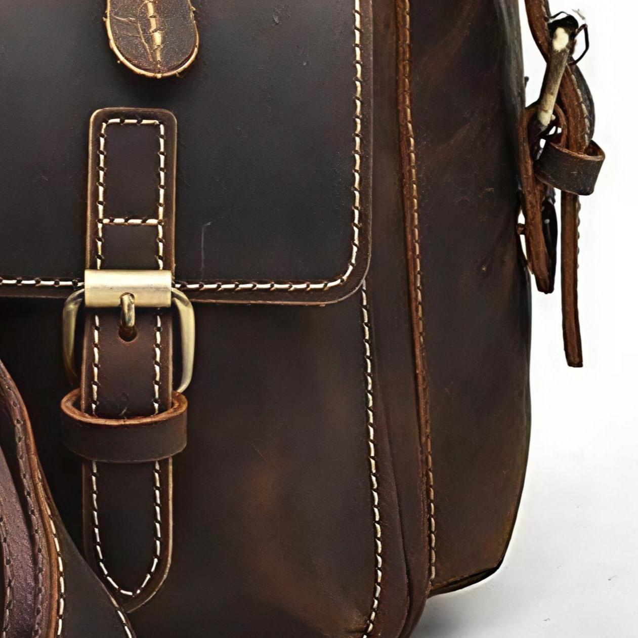 Close-up of a brown leather bag with gold buckle on a white background